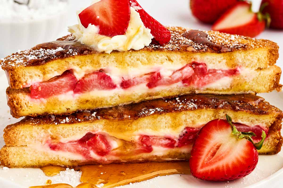 Close up of stacked French toast slices stuffed with cream cheese and strawberries.
