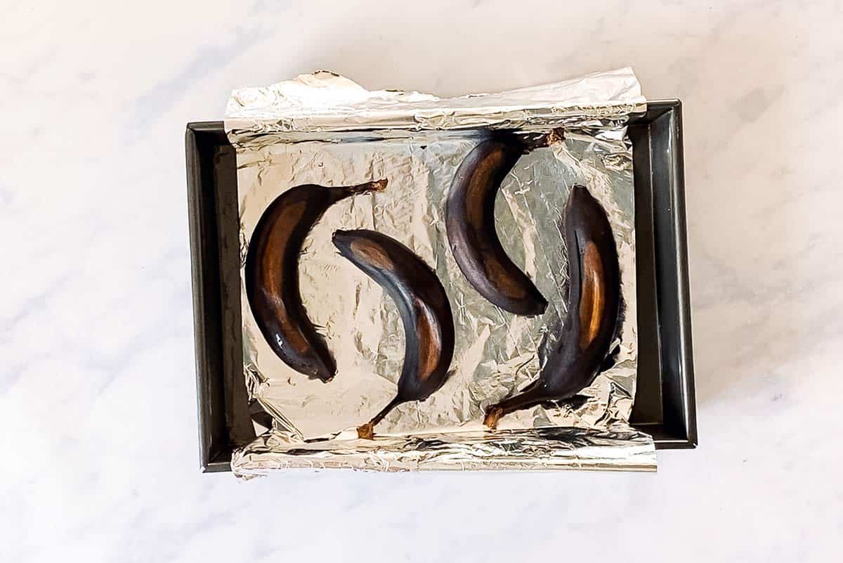 overhead view of foil lined baking pan with ripen bananas