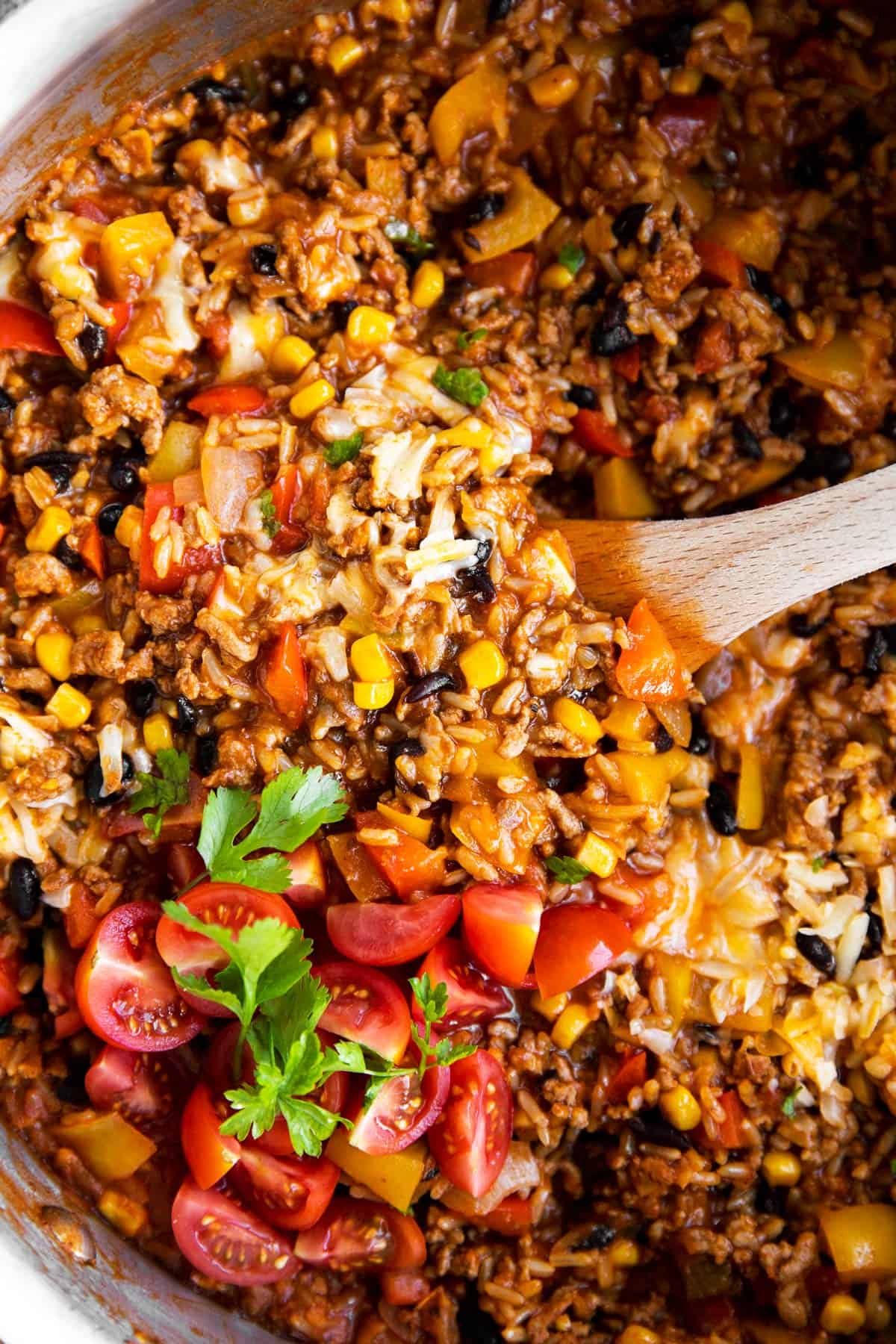 close up photo of Mexican beef and rice with fresh tomatoes on top