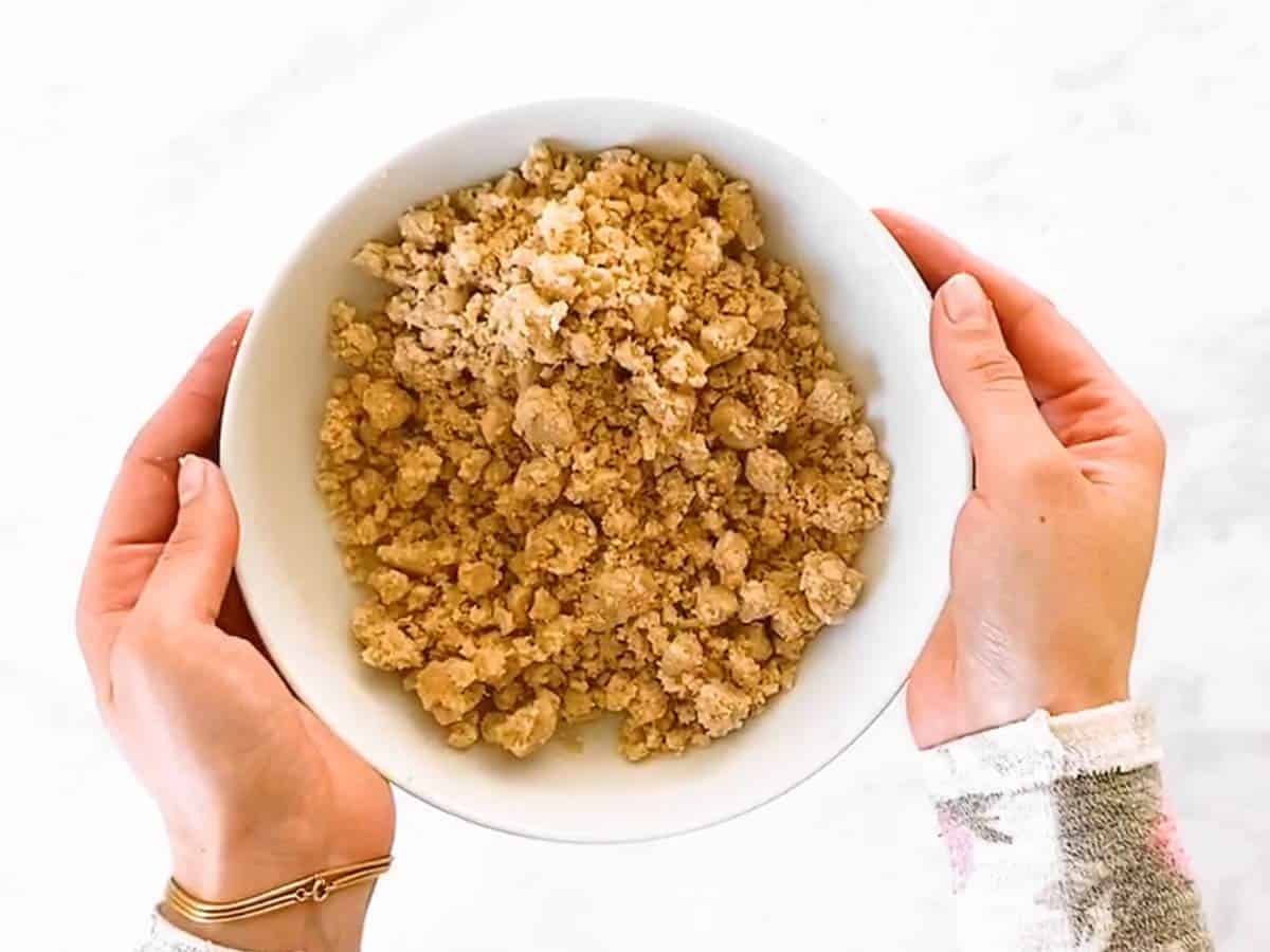 female hands holding bowl with streusel
