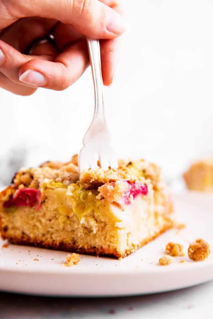 fork sticking into slice of rhubarb cake