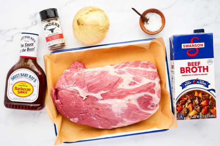 Ingredients for slow cooker BBQ pulled pork on a marble surface.