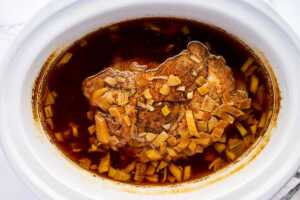 Cooked pork shoulder in slow cooker.