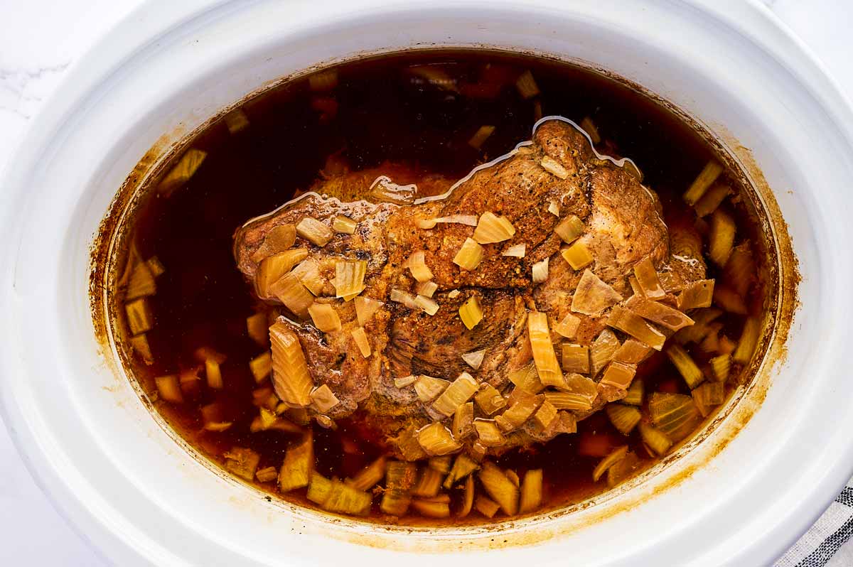 Cooked pork shoulder in slow cooker.