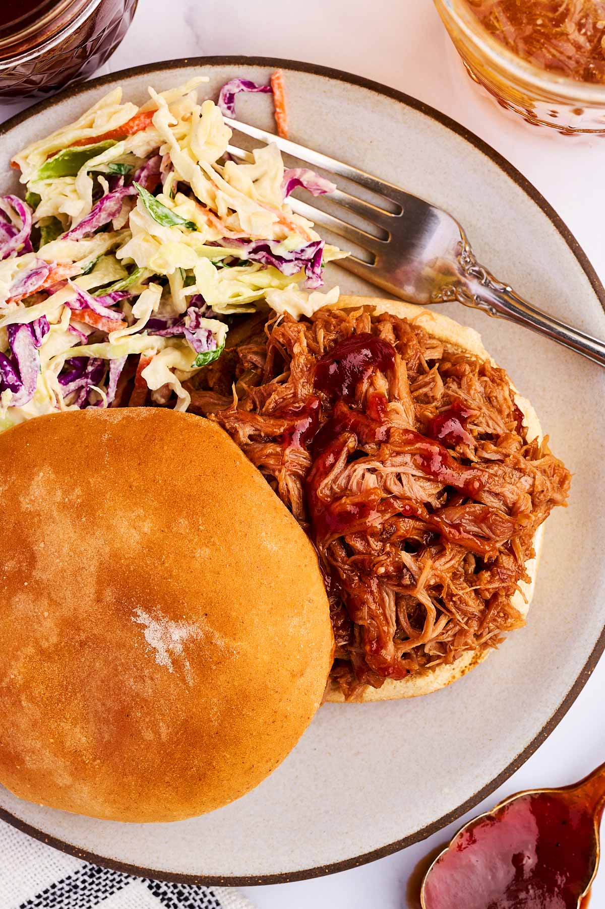 Plate with bun, pulled pork and coleslaw.
