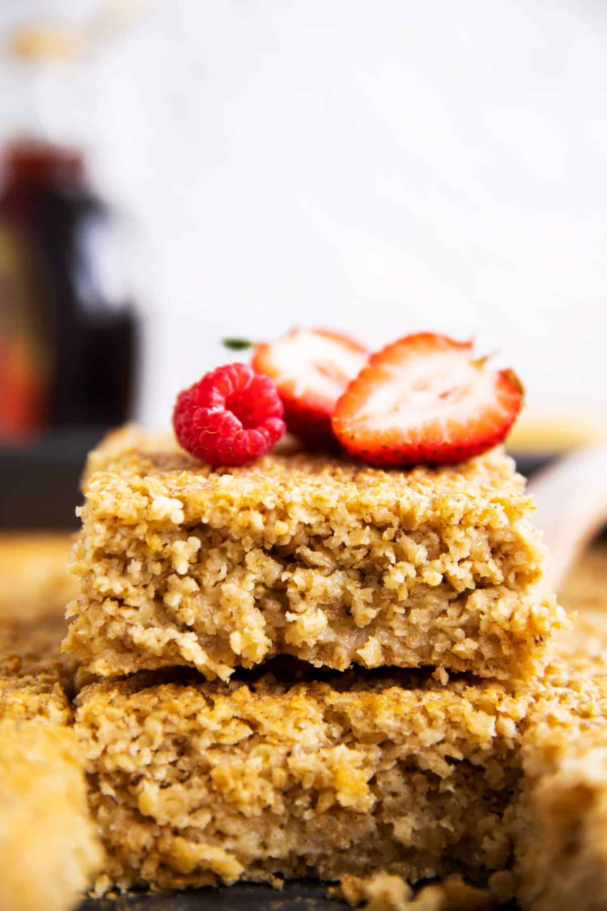 close up of stacked baked oatmeal slices with fresh berries