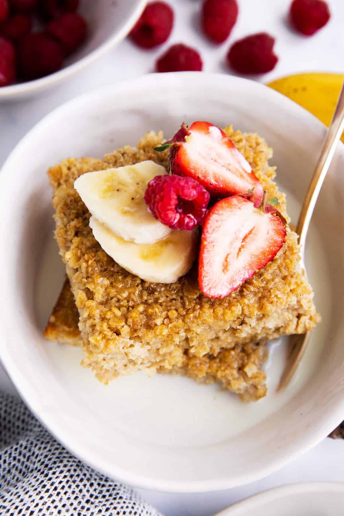 baked oatmeal and fruit in a bowl with milk