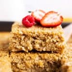 close up of stacked baked oatmeal slices with fresh berries