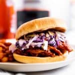 pulled pork sandwich with beer and crockpot in background