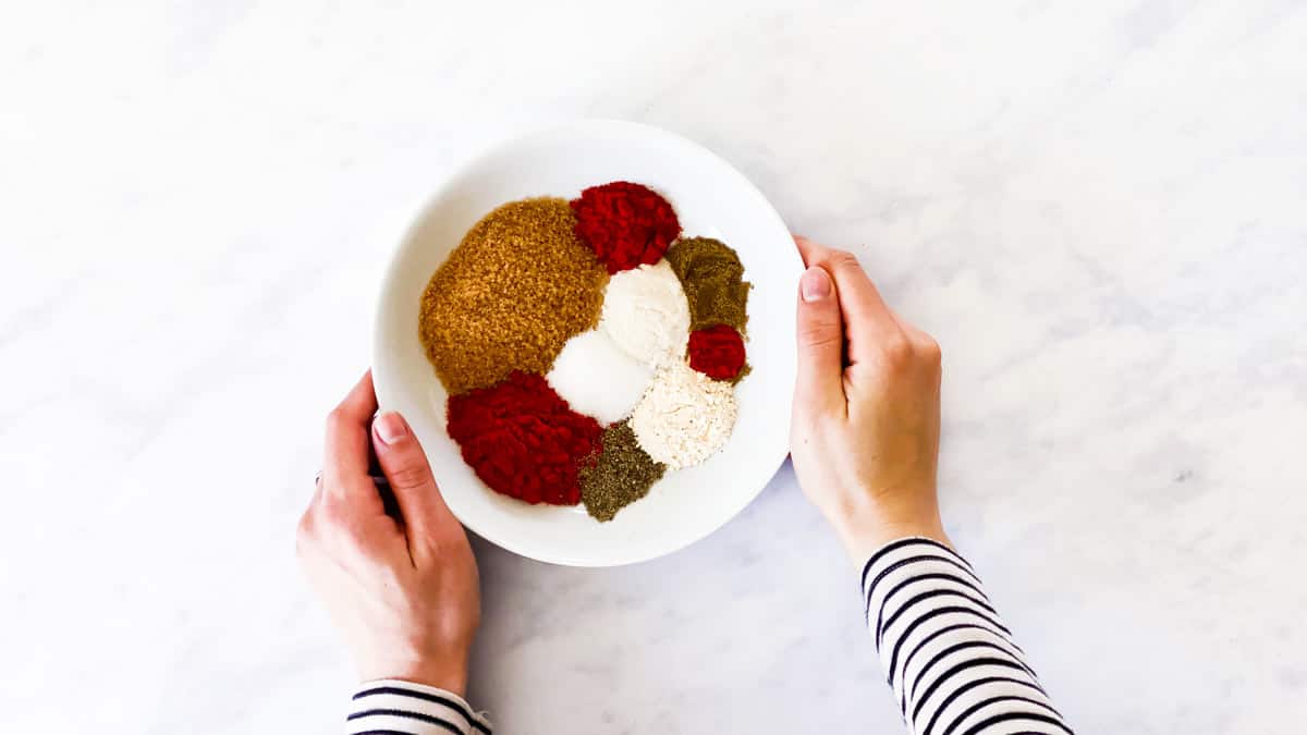 female hands holding bowl with spices