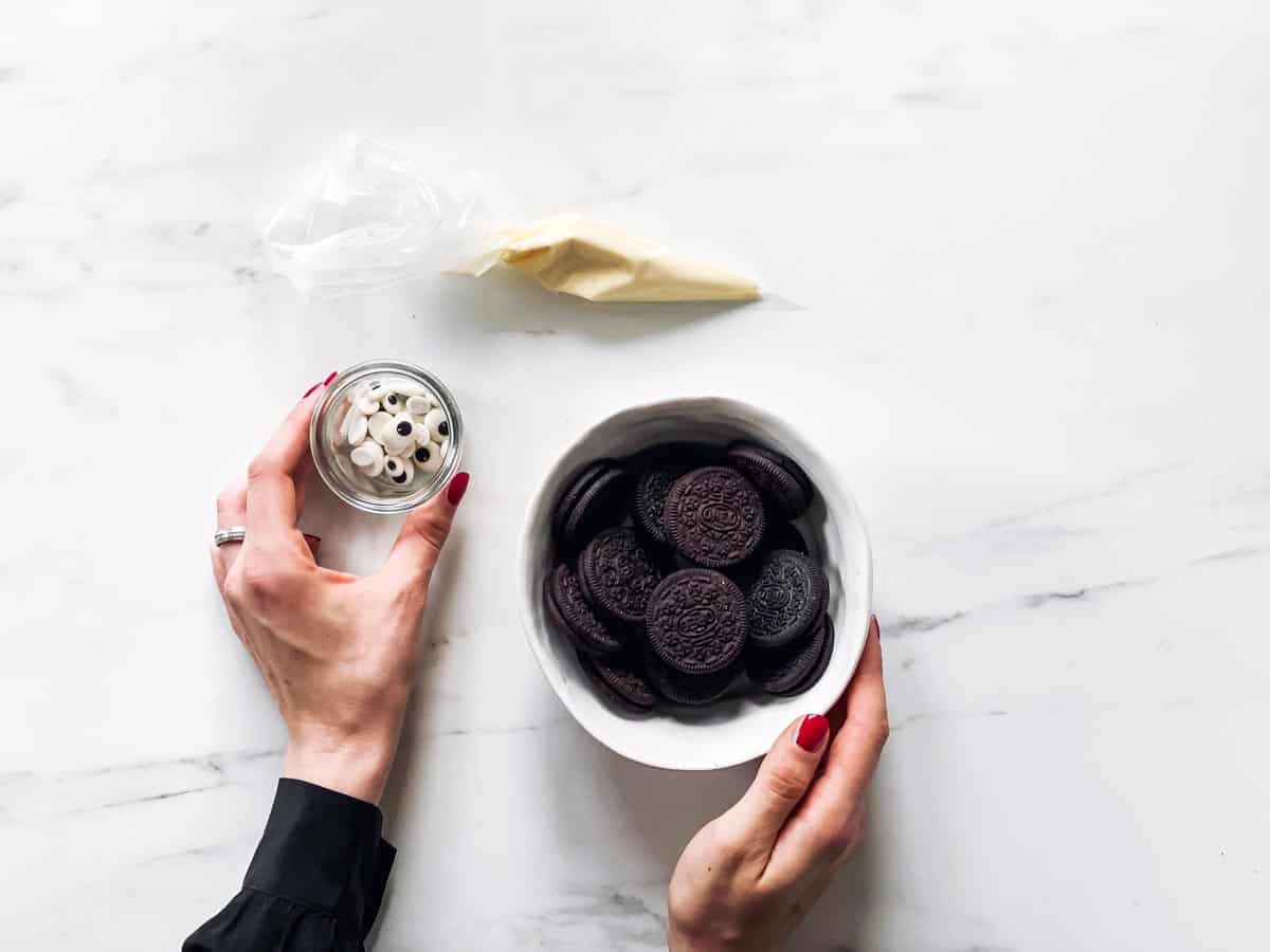 female hands holding ingredients for mummy Oreos