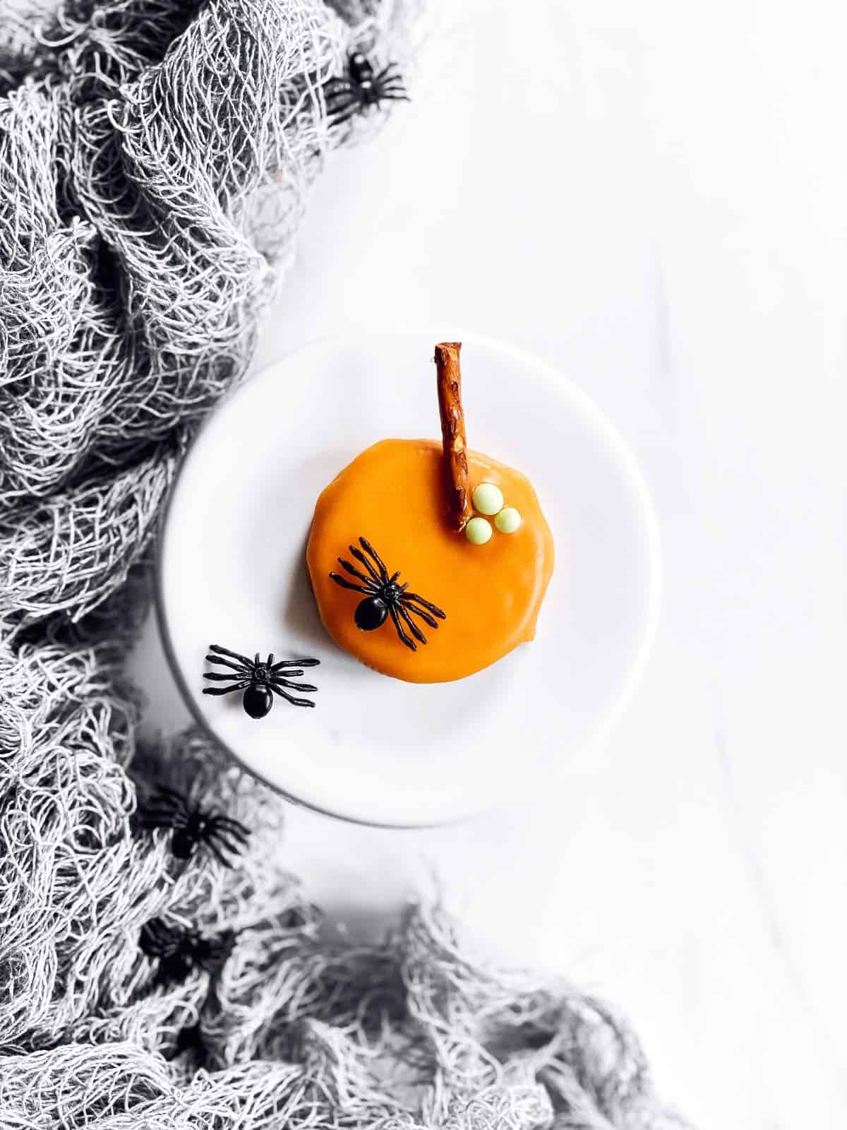 pumpkin decorated Oreo and miniature cake stand with plastic spiders