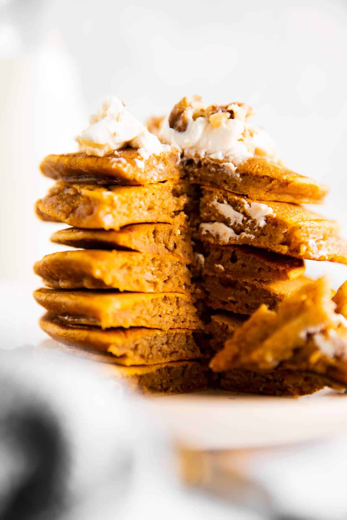 stack of cut open pumpkin pancakes on a white plate