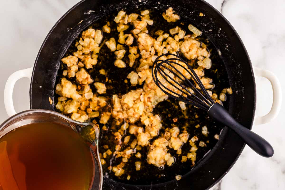 Whisking broth into skillet.