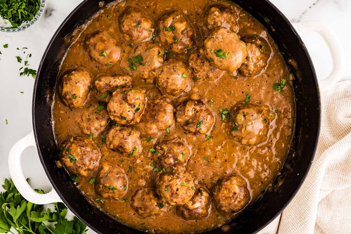 Meatballs in gravy in a skillet.