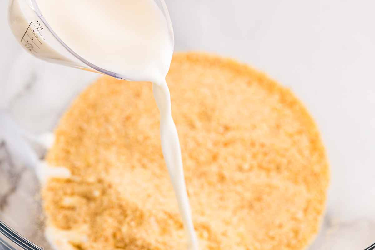 Pouring milk into breadcrumbs.