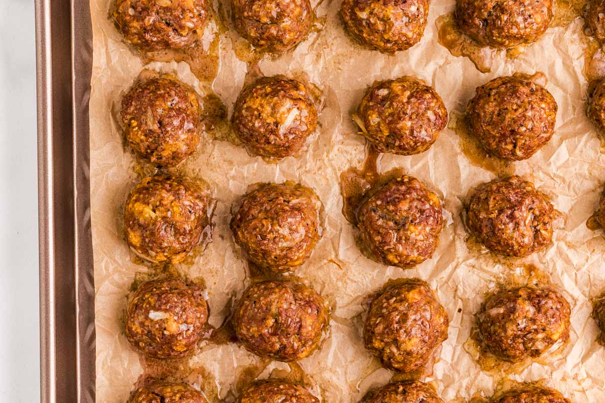 Baked meatballs on a sheet pan.