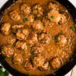 Meatballs in gravy in a skillet.