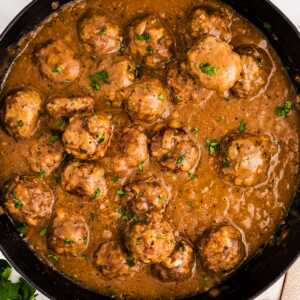 Meatballs in gravy in a skillet.