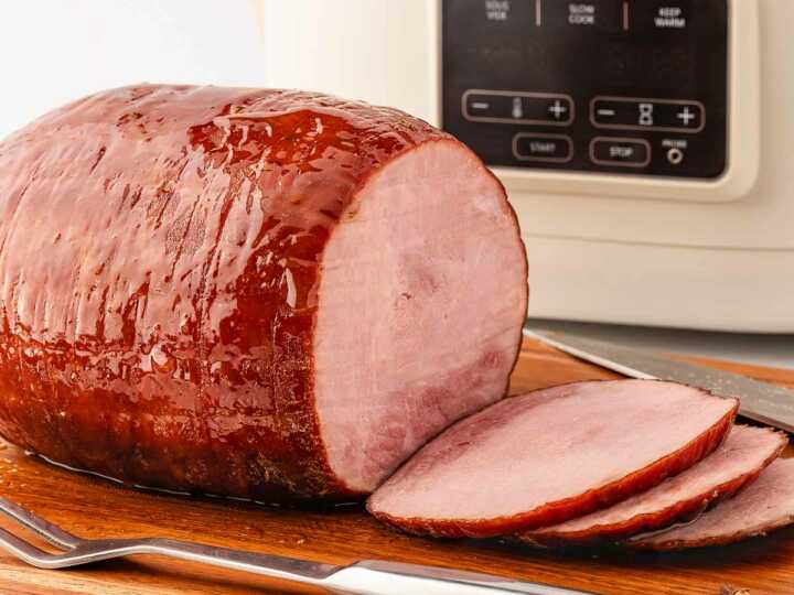 frontal view of glazed ham in front of slow cooker