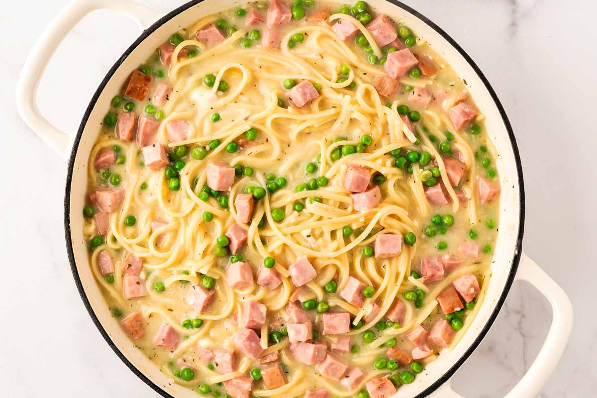 Creamy ham and pea linguine in a pot.
