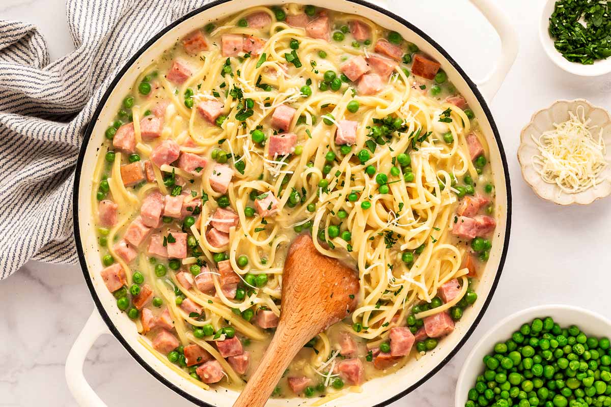 Serving a pot of ham and pea pasta.