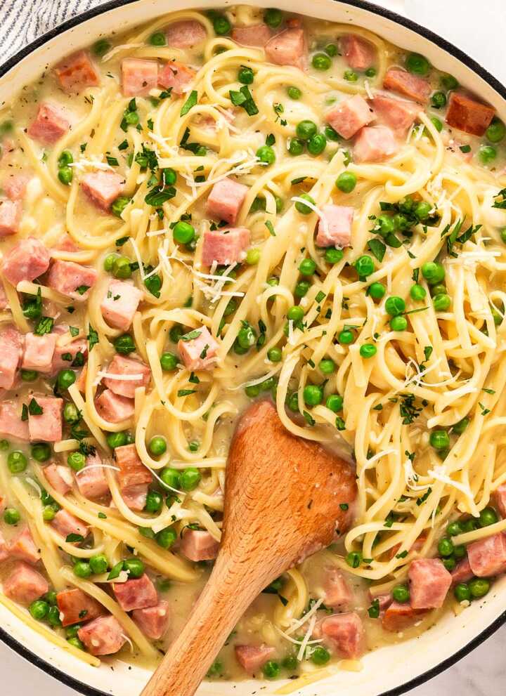 Serving a pot of ham and pea pasta.