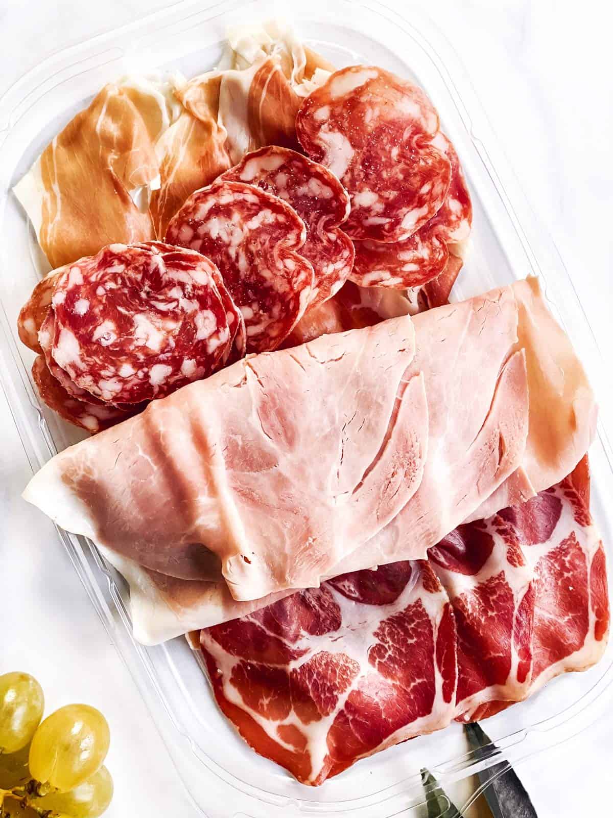 several cold cuts on plastic platter