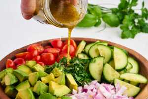 pouring dressing over salad