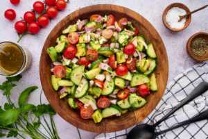 cucumber tomato avocado salad in wooden bowl