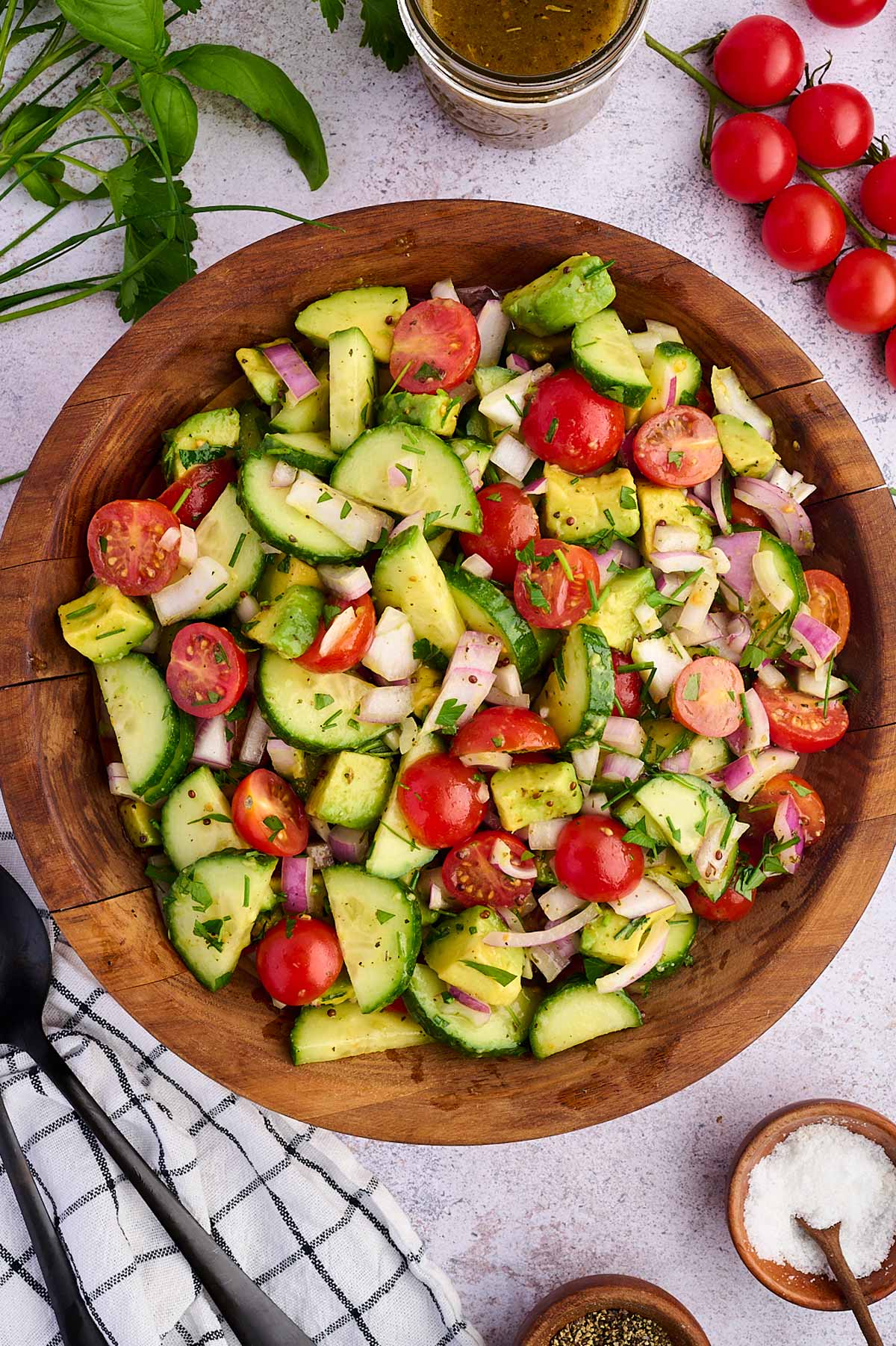 cucumber tomato avocado salad in wooden bowl