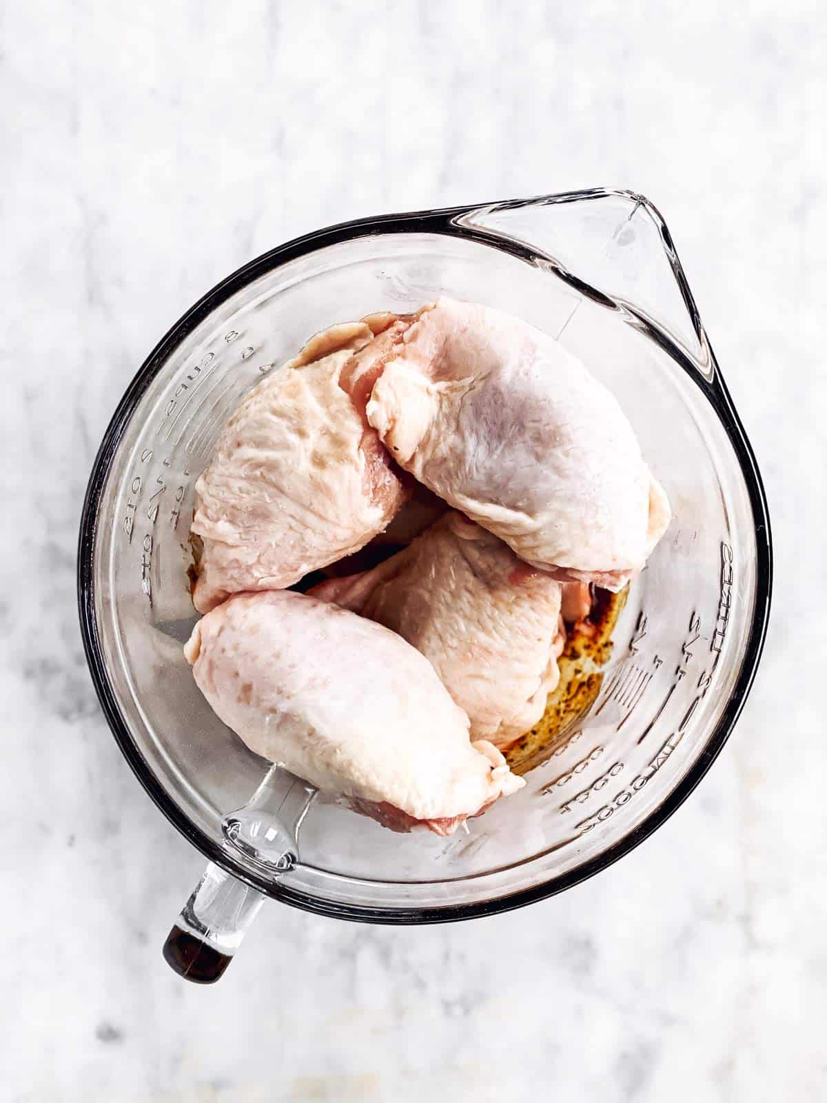 raw chicken thighs in glass bowl