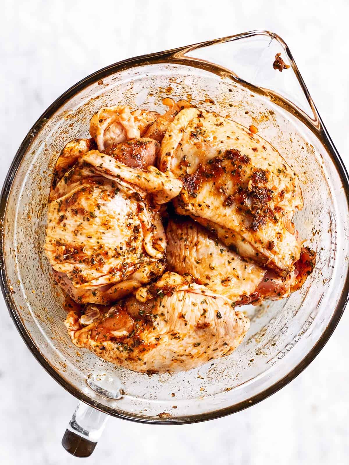 seasoned chicken thighs in glass bowl