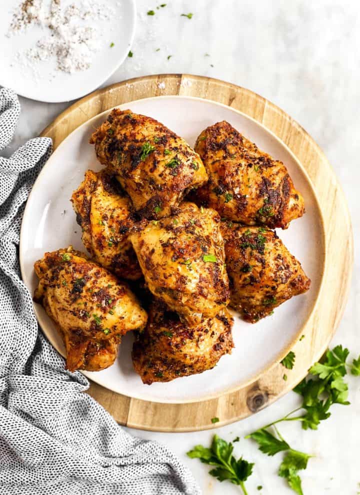 overhead view of plate on wooden platter with chicken thighs
