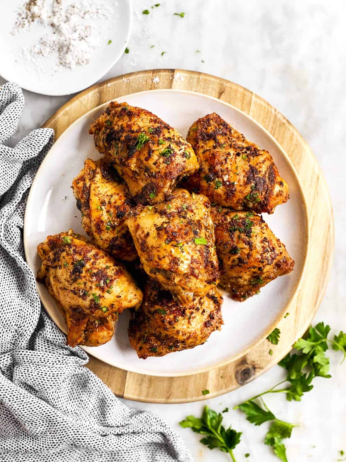 overhead view of plate on wooden platter with chicken thighs