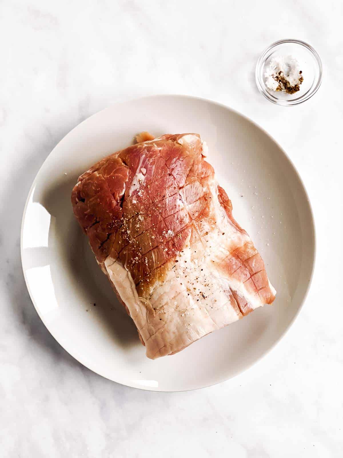 raw pork roast on white plate