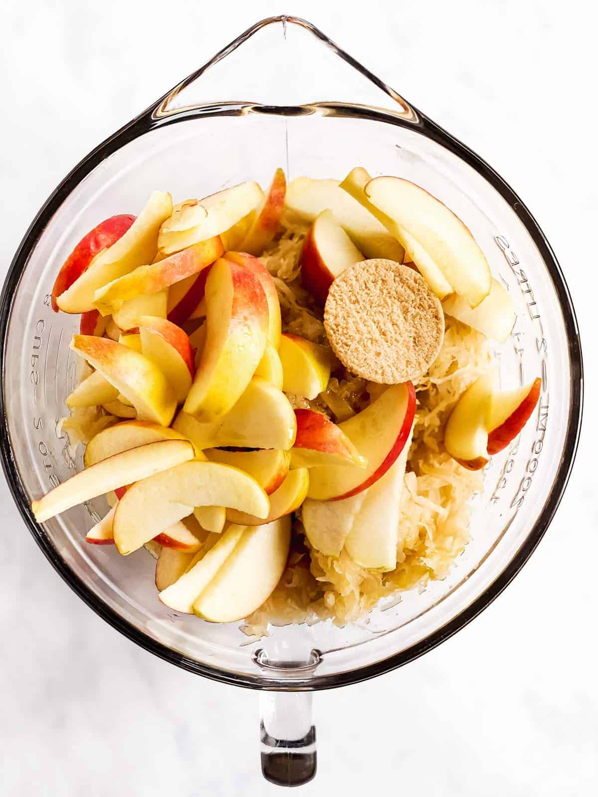 glass bowl with apples, sauerkraut, maple syrup and brown sugar