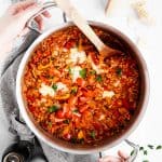 female hands holding skillet with unstuffed peppers