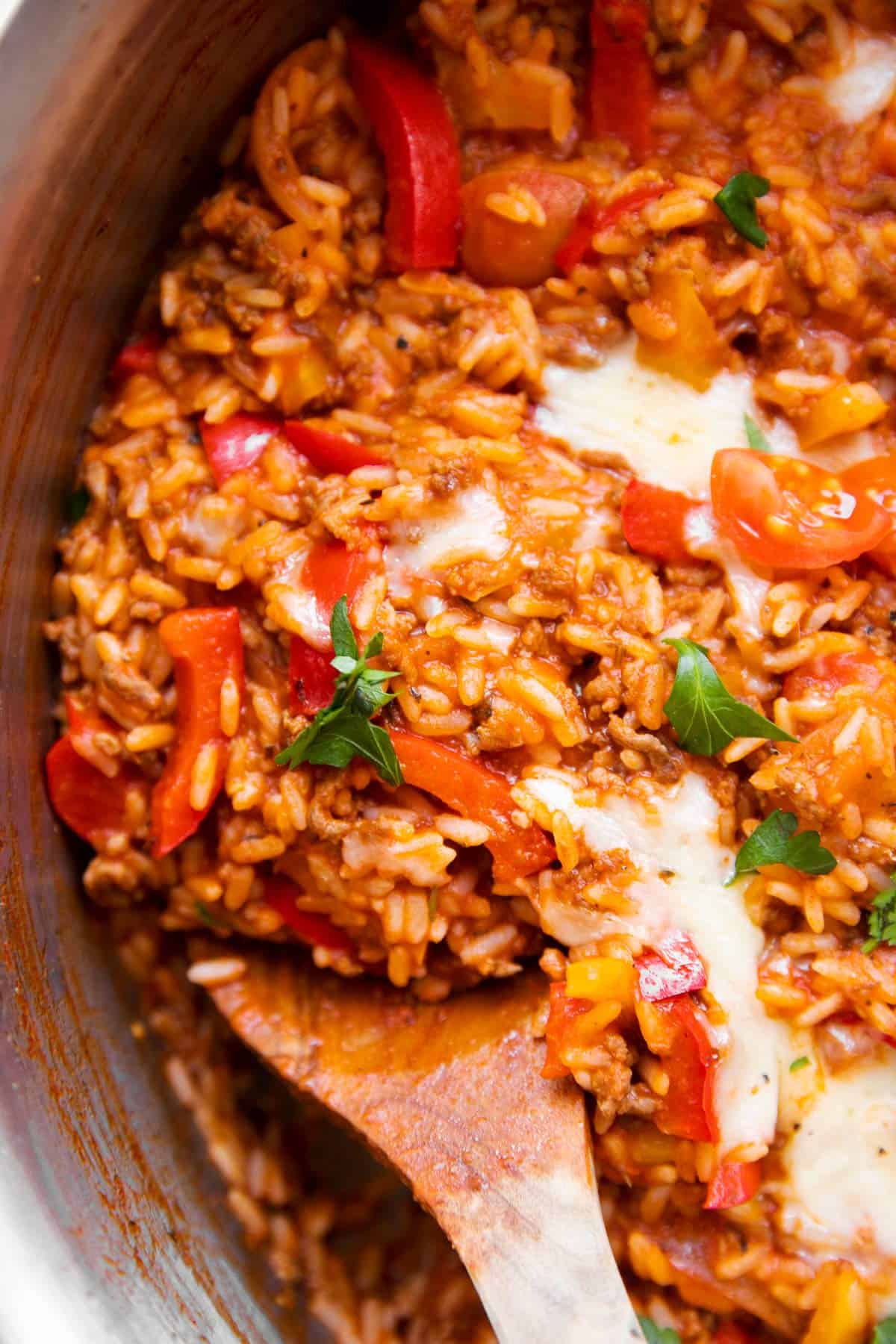 close up of wooden spoon in unstuffed pepper skillet