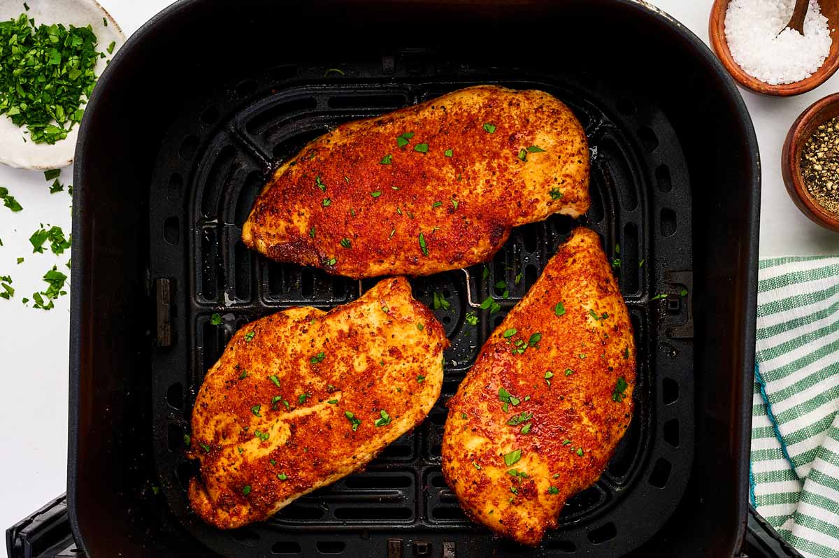 Chicken breast in air fryer basket.