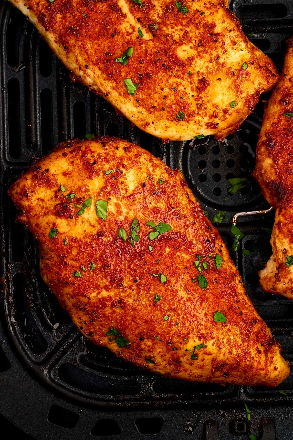 Air fried chicken breast in air fryer basket.