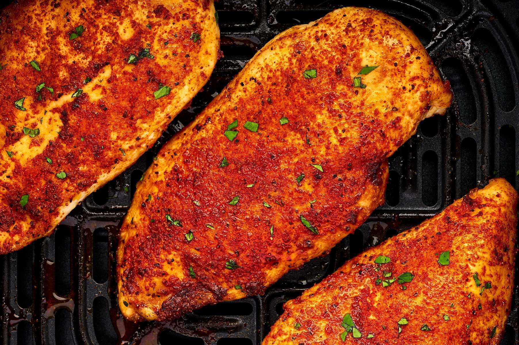 Chicken breast in air fryer basket.