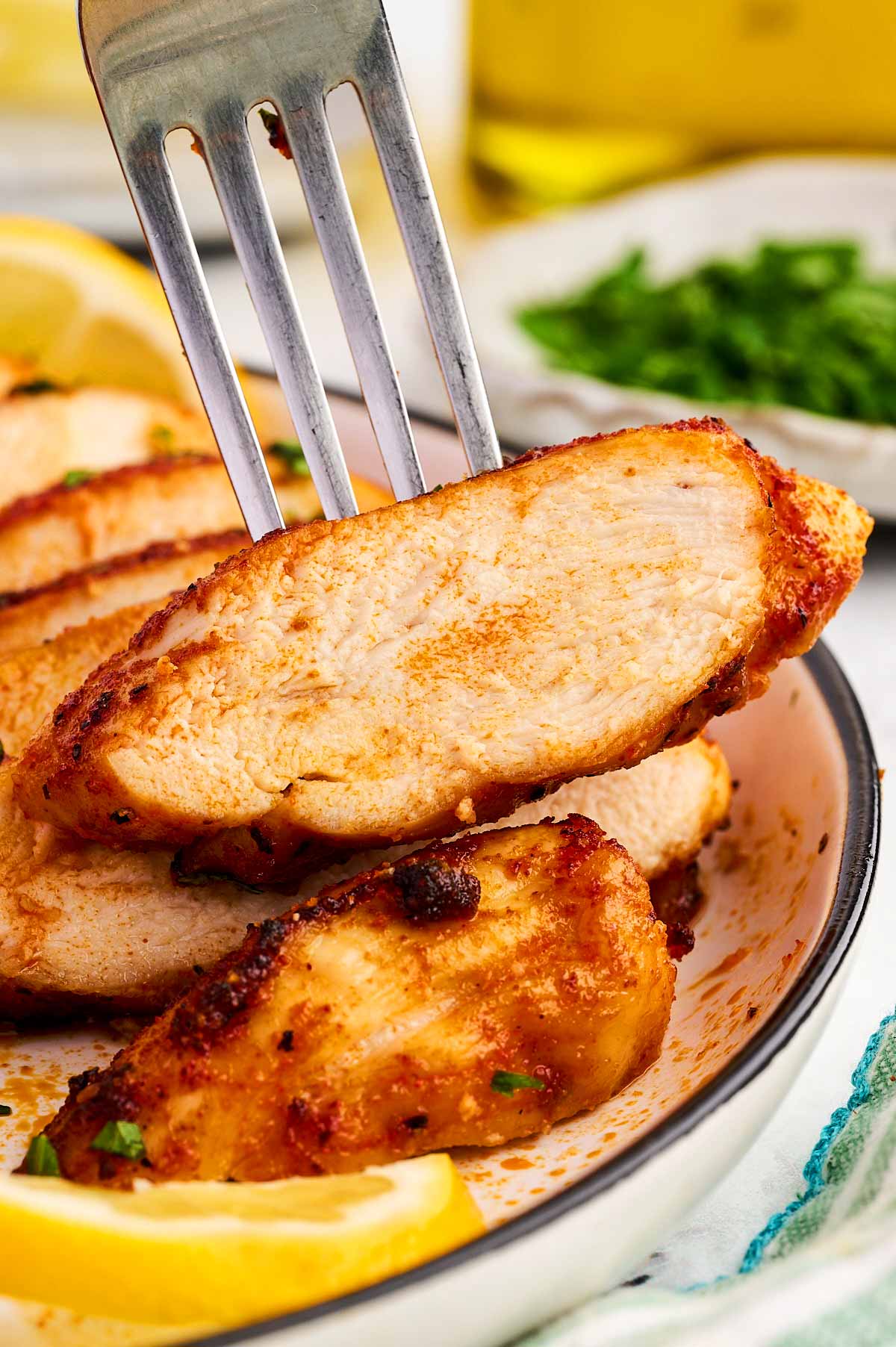Sliced air fried chicken breast on a fork.