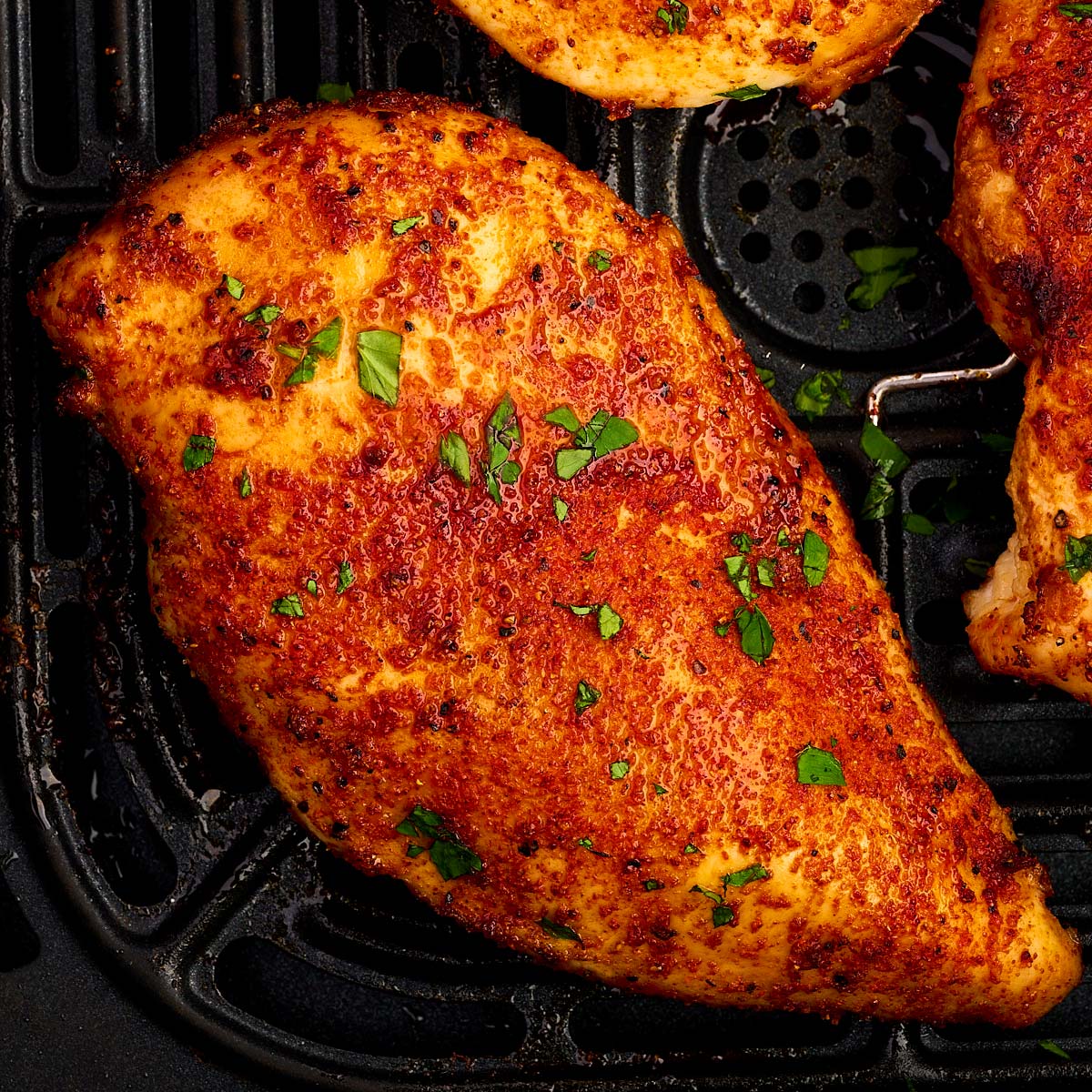 Air fried chicken breast in air fryer basket.