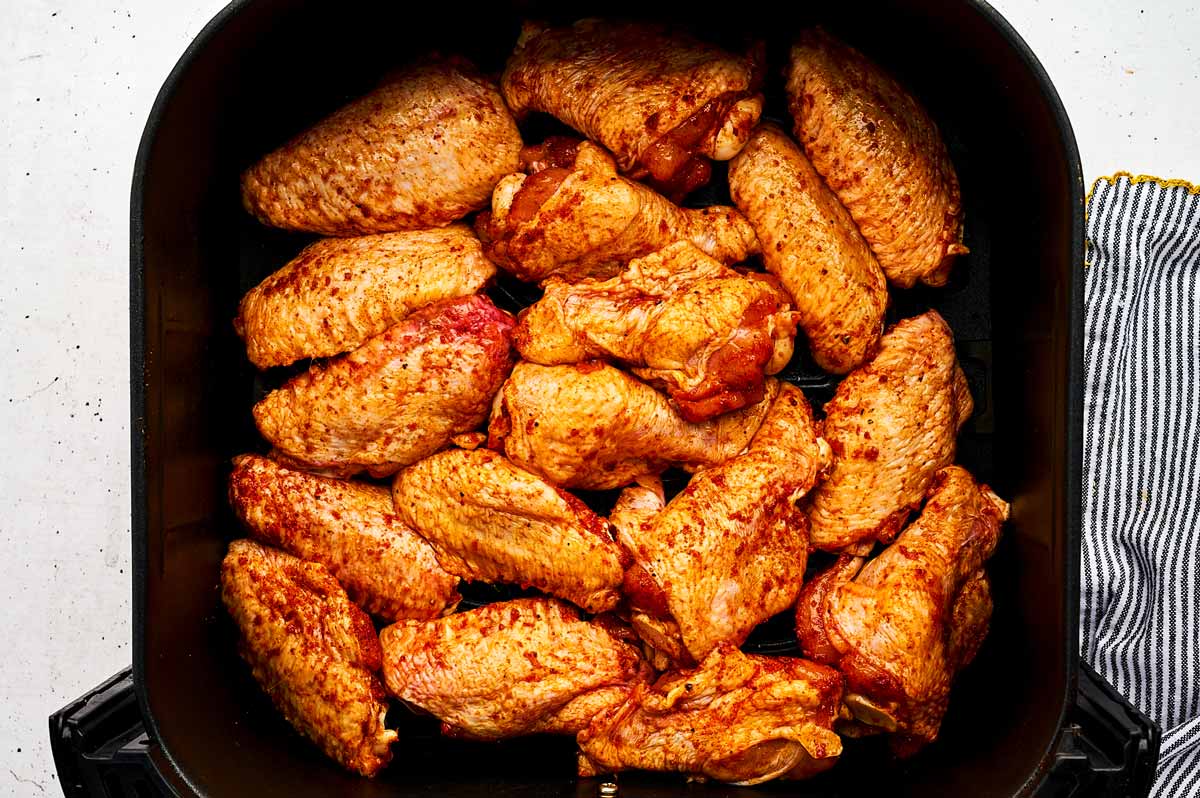 Chicken wings in air fryer basket.