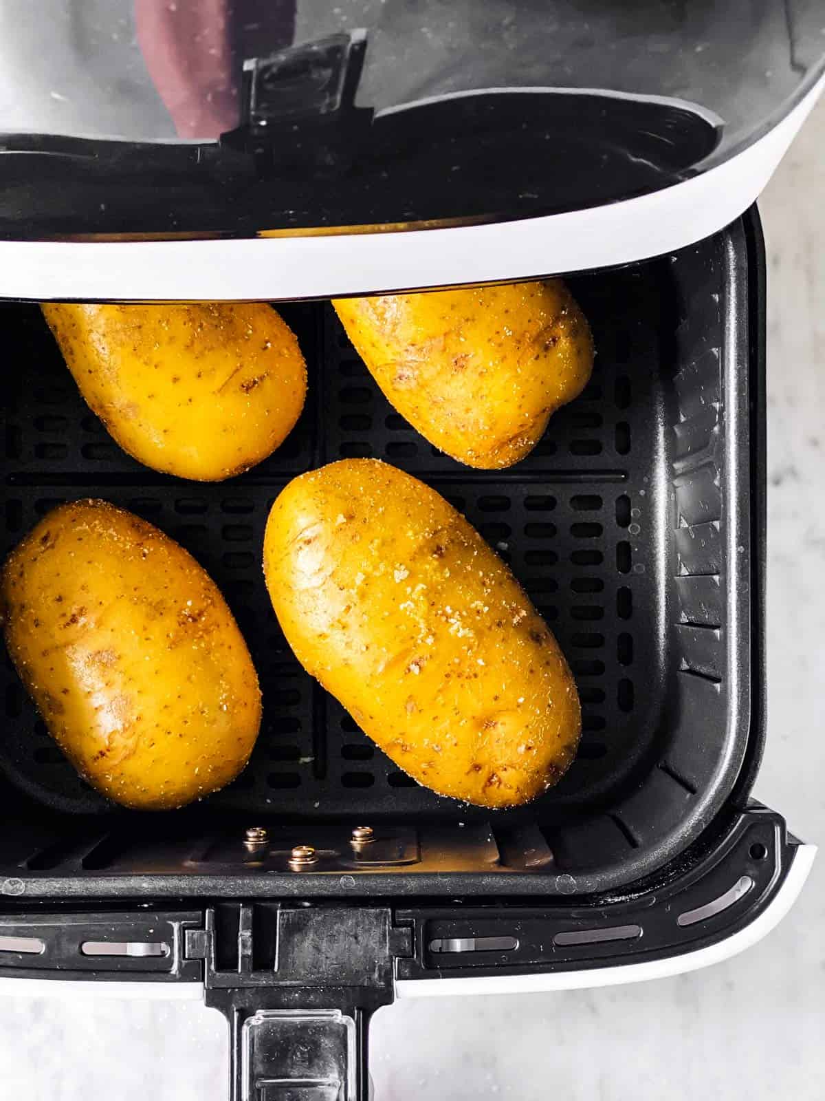 raw russet potatoes in air fryer basket