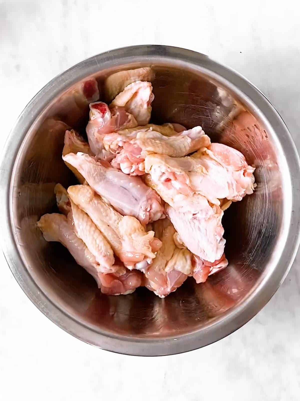 bowl with raw chicken wings