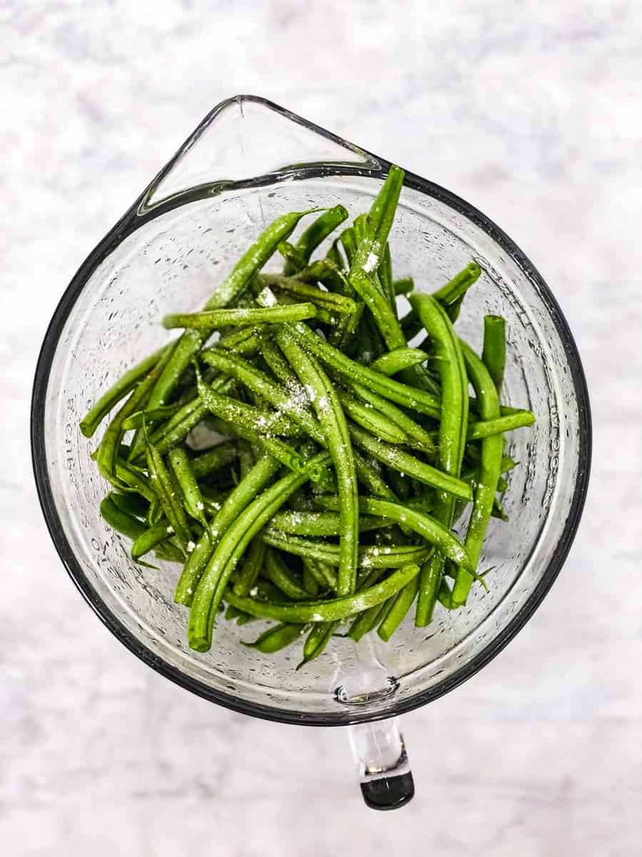 glass bowl with seasoned raw green beans