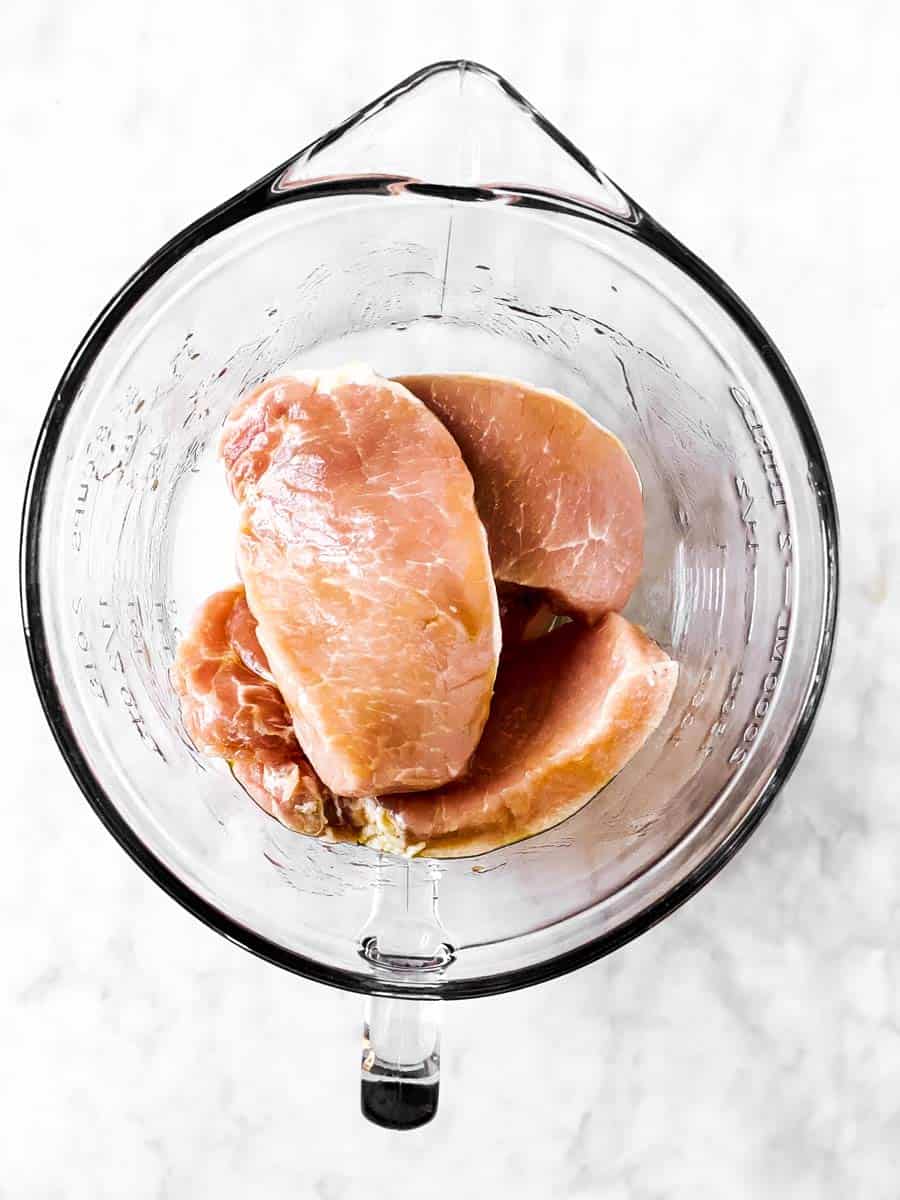 pork chops in glass bowl with olive oil