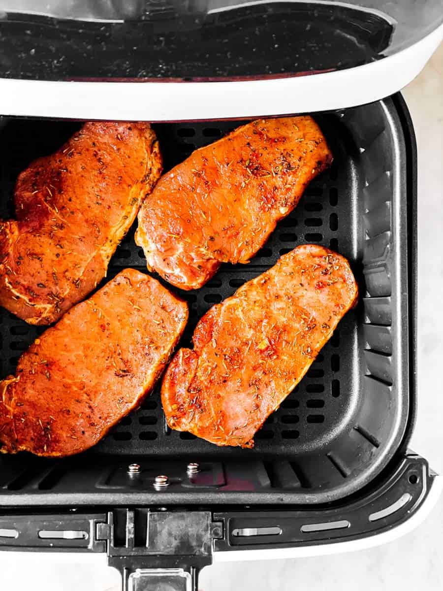 raw seasoned pork chops in air fryer basket